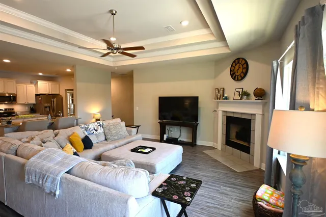 a living room with furniture a fireplace and a ceiling fan