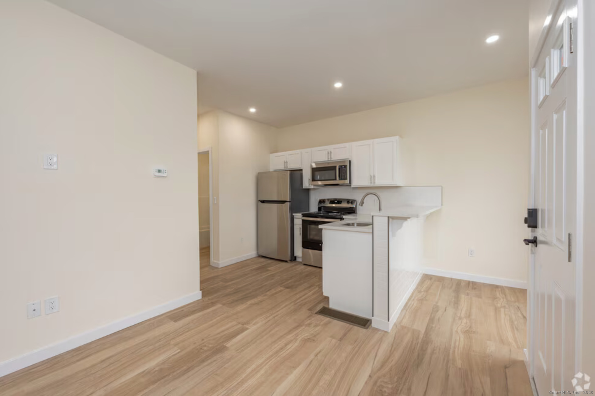 a kitchen with white cabinets and stainless steel appliances