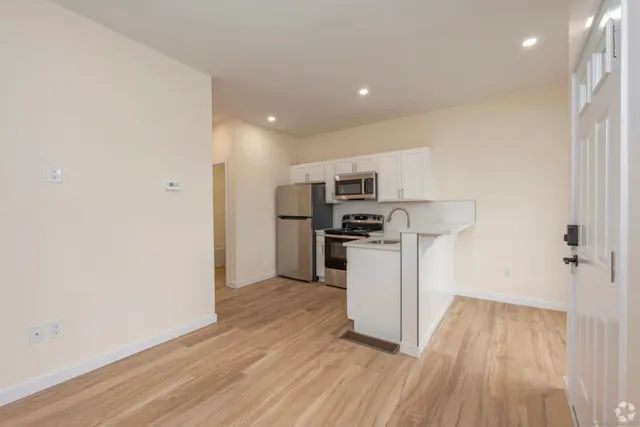 a kitchen with white cabinets and stainless steel appliances
