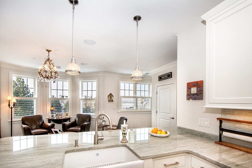 151 HMS Stayner Drive, Unit 151 Hingham, MA 02043 - Photo 16 of 42 a living room with furniture and a chandelier
