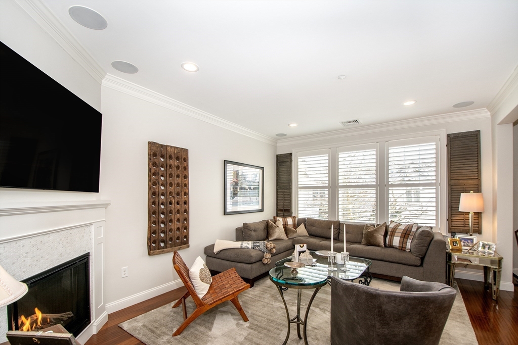 151 HMS Stayner Drive, Unit 151 Hingham, MA 02043 - Photo 25 of 42 a living room with furniture a flat screen tv and a fireplace