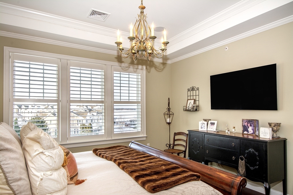 151 HMS Stayner Drive, Unit 151 Hingham, MA 02043 - Photo 30 of 42 a bedroom with a bed and a flat screen tv