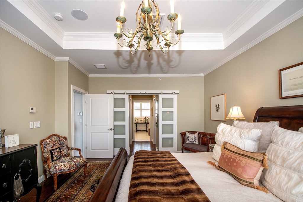 151 HMS Stayner Drive, Unit 151 Hingham, MA 02043 - Photo 33 of 42 a bedroom with a bed and ceiling fan