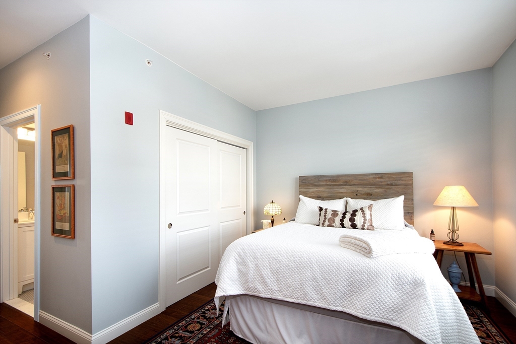 151 HMS Stayner Drive, Unit 151 Hingham, MA 02043 - Photo 37 of 42 a bedroom with a bed and a lamp