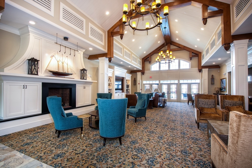 151 HMS Stayner Drive, Unit 151 Hingham, MA 02043 - Photo 42 of 42 a living room with furniture a fireplace and a chandelier