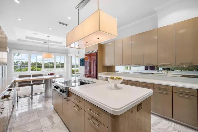 a large kitchen with a large counter top space a sink stainless steel appliances and cabinets