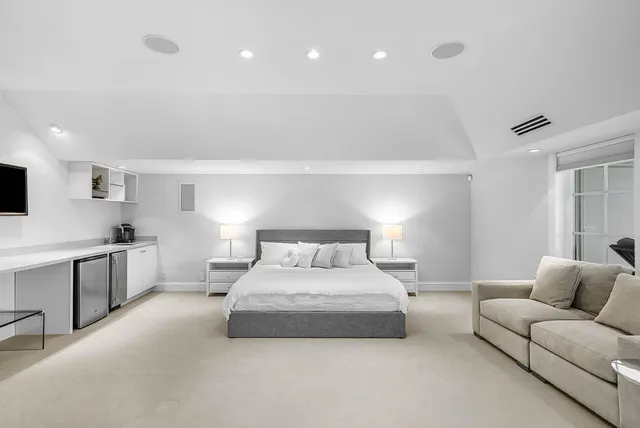 a large bedroom with a large bed and windows