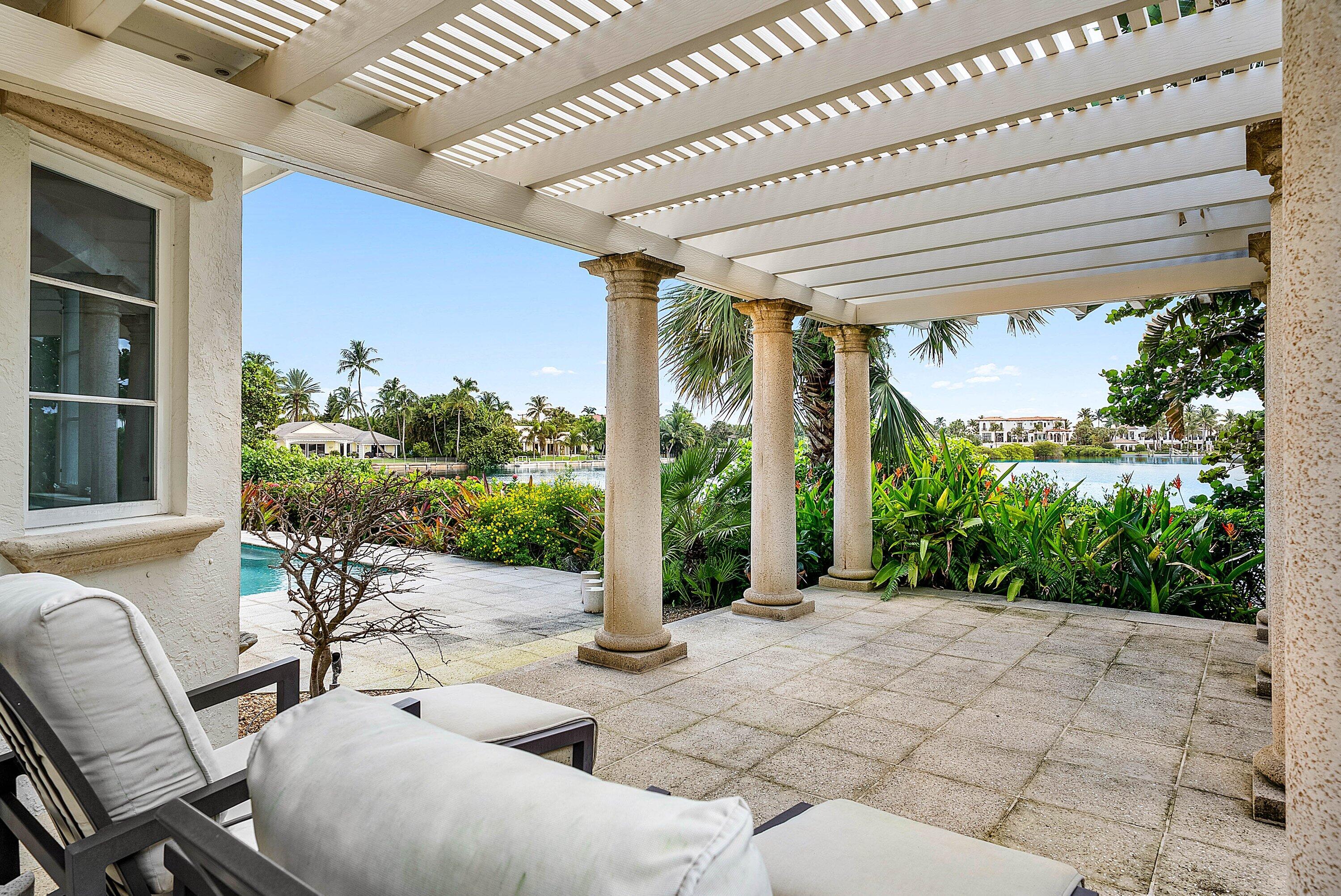 1620 Lands End Road Manalapan, FL 33462 - Photo 30 of 34 a view of a patio with table and chairs potted plants and floor to ceiling window