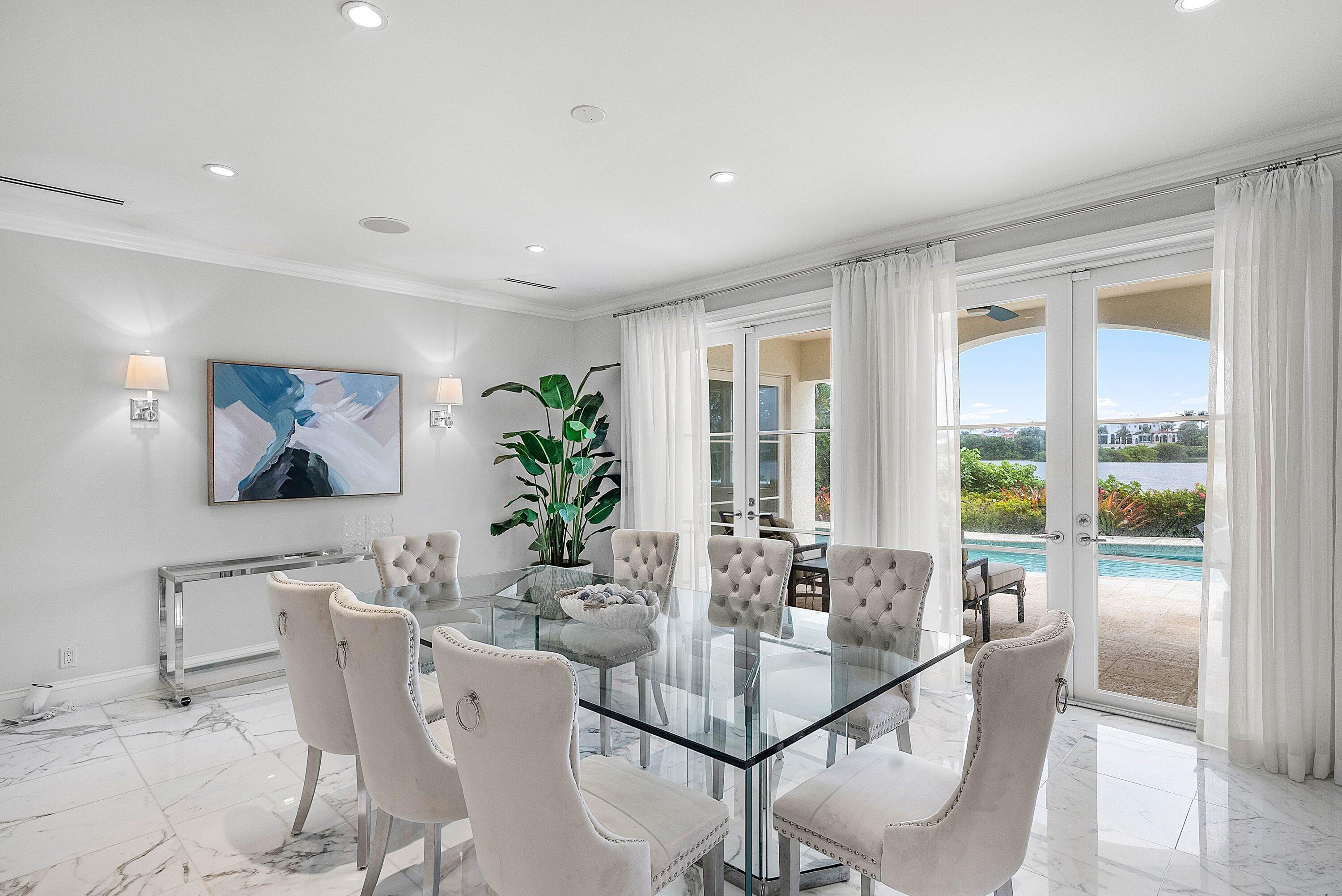 1620 Lands End Road Manalapan, FL 33462 - Photo 10 of 34 a dining room with furniture large windows and a potted plant
