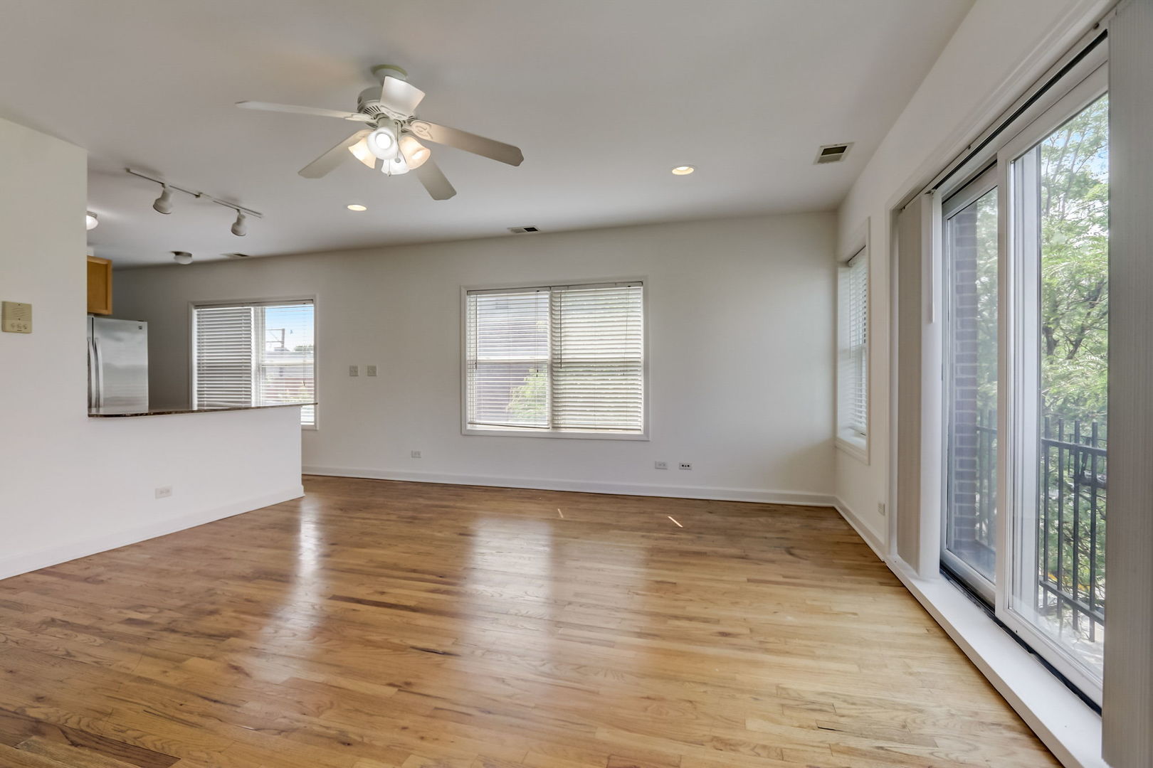 2457 West Harrison Street, Unit 3 Chicago, IL 60612 - Photo 3 of 20 an empty room with wooden floor and windows