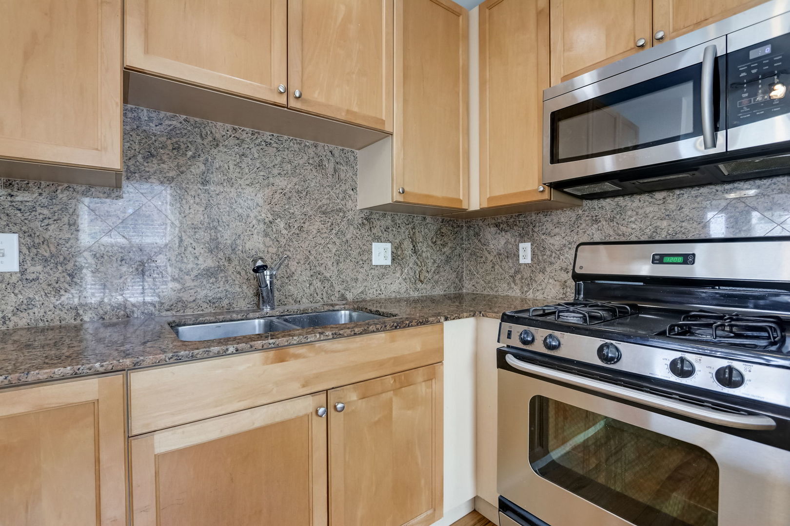2457 West Harrison Street, Unit 3 Chicago, IL 60612 - Photo 5 of 20 a kitchen with stainless steel appliances granite countertop white cabinets stove a sink and dishwasher