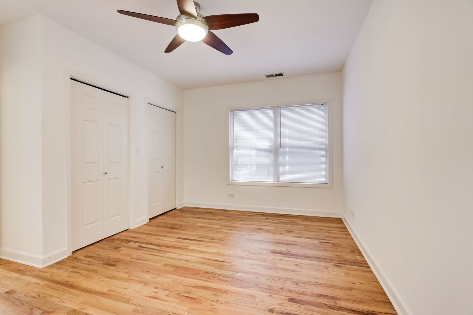 2457 West Harrison Street, Unit 3 Chicago, IL 60612 - Photo 9 of 20 a view of an empty room with wooden floor and a window