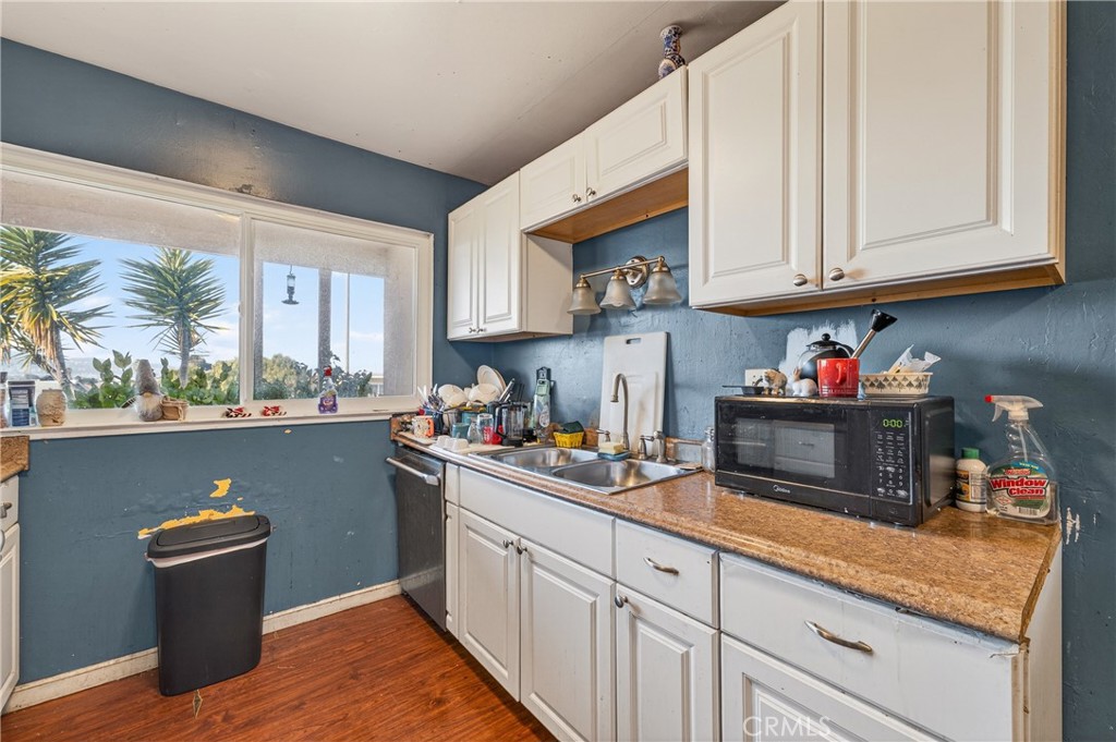 1688 Harding Street Seaside, CA 93955 - Photo 15 of 37 a kitchen with stainless steel appliances granite countertop a sink dishwasher and cabinets with wooden floor