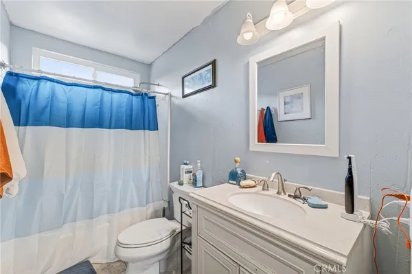 a bathroom with a sink vanity mirror and toilet