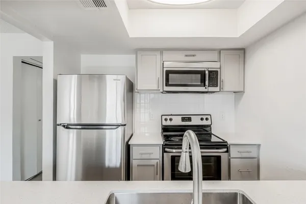 a kitchen with stainless steel appliances and refrigerator