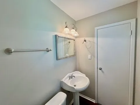 a bathroom with a toilet a sink and mirror