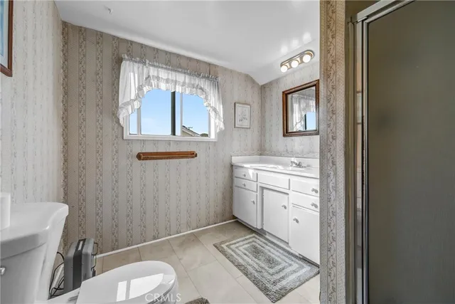 a bathroom with a granite countertop toilet sink and mirror