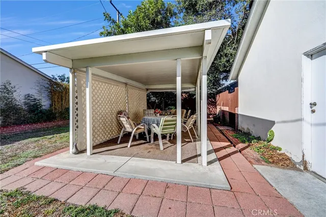 a view of a patio with table and chairs with wooden floor and fence