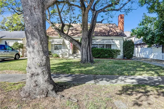 a view of a house with a tree in the yard