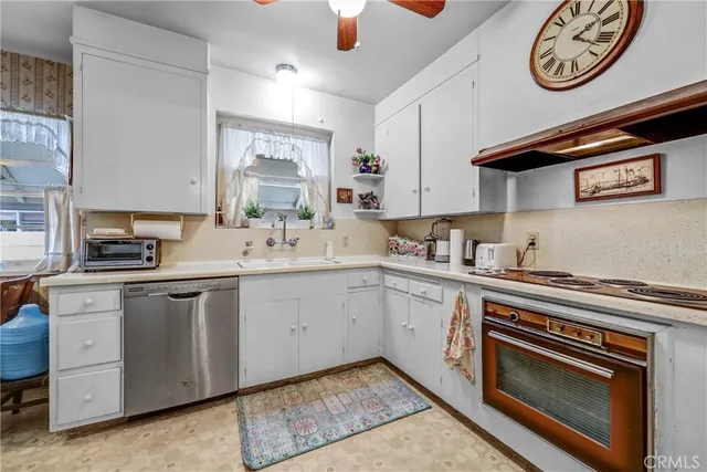 a kitchen with a stove cabinets and a window