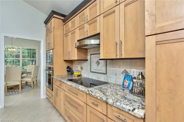 a kitchen with stainless steel appliances granite countertop a sink stove and cabinets