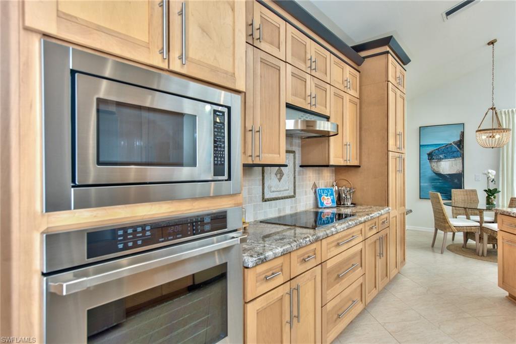 1705 Marsh Run Naples, FL 34109 - Photo 12 of 40 a kitchen with stainless steel appliances granite countertop a stove and cabinets