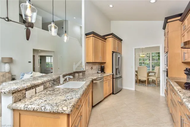 a kitchen with granite countertop a sink and a refrigerator