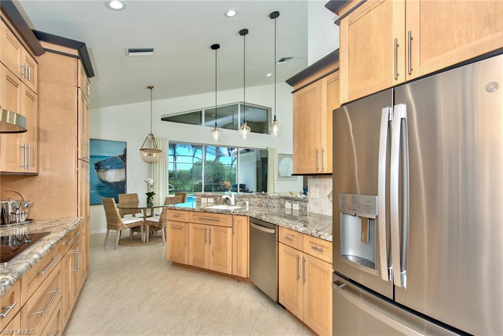 1705 Marsh Run Naples, FL 34109 - Photo 14 of 40 a kitchen with stainless steel appliances a refrigerator a sink dishwasher a stove and white cabinets with wooden floor