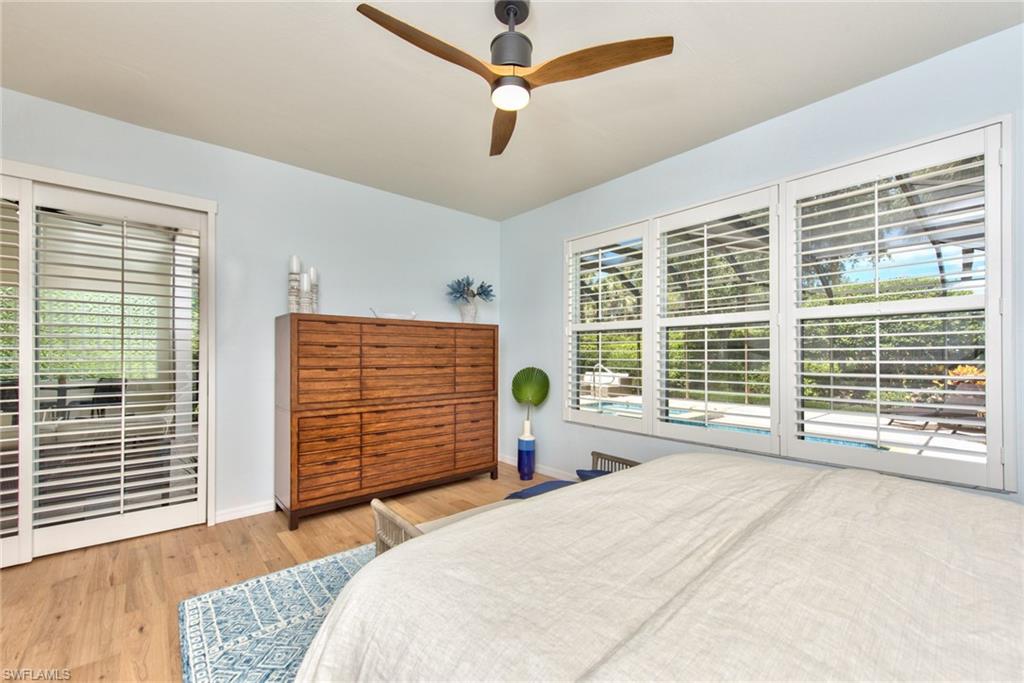 1705 Marsh Run Naples, FL 34109 - Photo 16 of 40 a bedroom with a bed a dresser and a large window