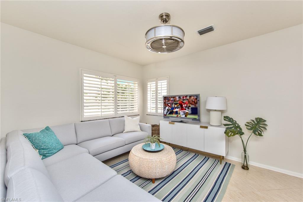 1705 Marsh Run Naples, FL 34109 - Photo 21 of 40 a living room with furniture and a chandelier