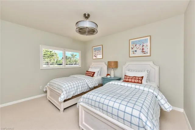 a bedroom with two beds and a chandelier