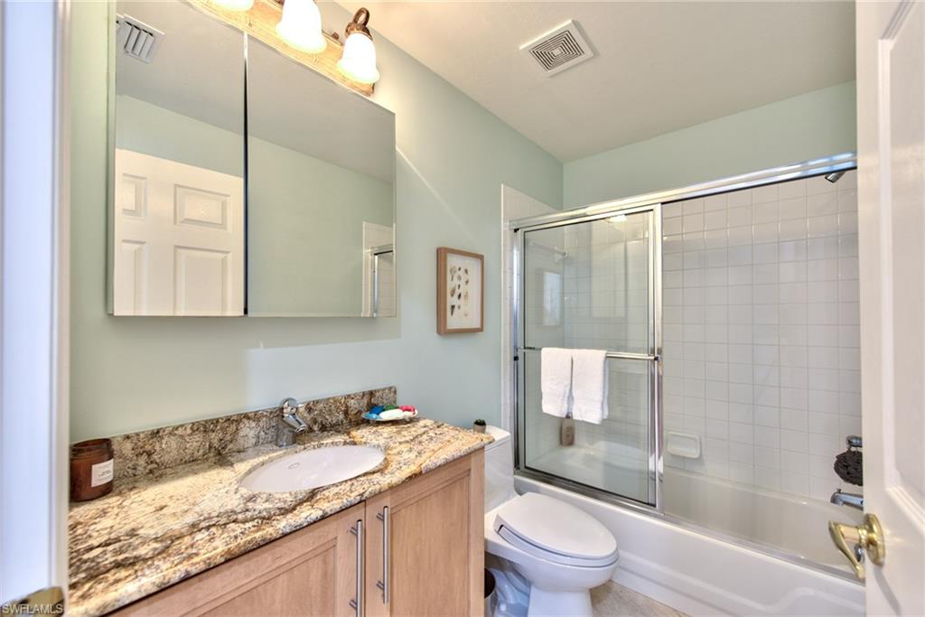 1705 Marsh Run Naples, FL 34109 - Photo 27 of 40 a bathroom with a granite countertop sink toilet and shower