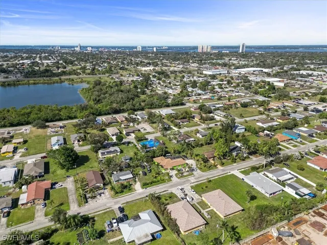an aerial view of residential houses with outdoor space and lake view