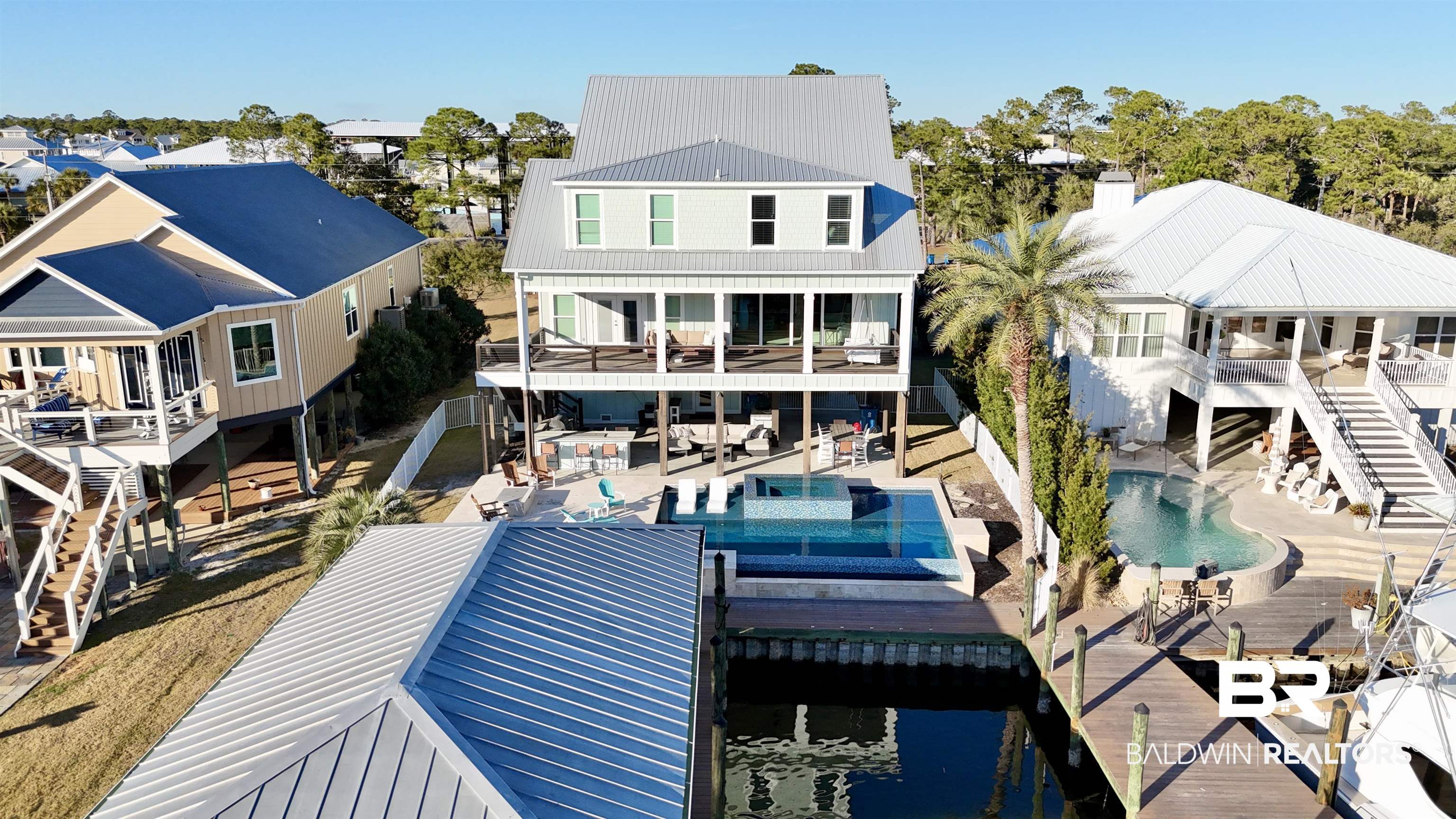 27044 Marina Road Orange Beach, AL 36561 - Photo 2 of 2 Rear view of property featuring a patio area, a community pool, a metal roof, and a residential view