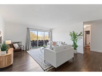 a living room with furniture and a floor to ceiling window