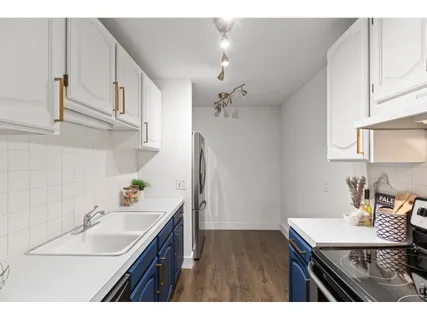 a kitchen with white cabinets and chairs