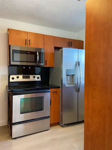 a kitchen with stainless steel appliances a stove a microwave and cabinets