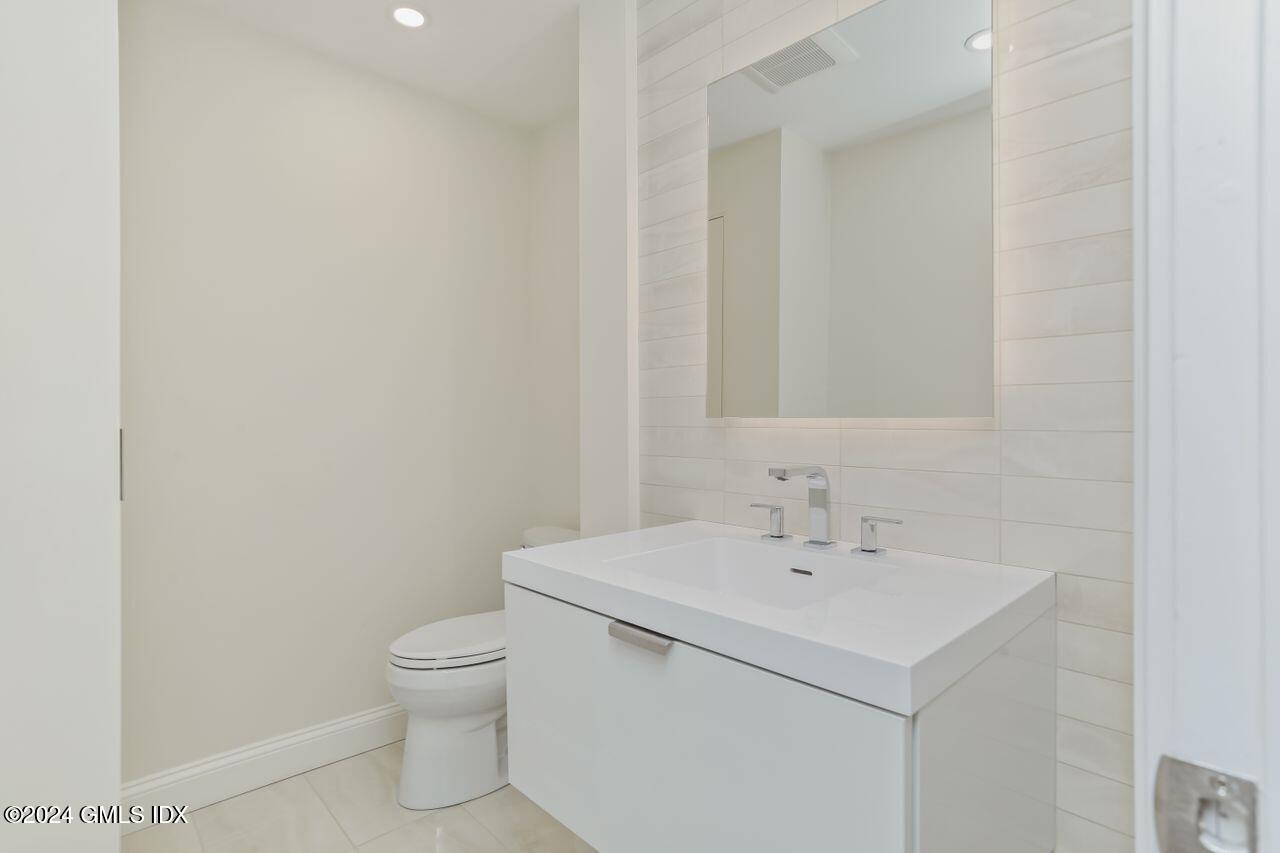 40 West Elm Street, Unit 3G Greenwich, CT 06830 - Photo 12 of 20 a bathroom with a sink a toilet and a mirror