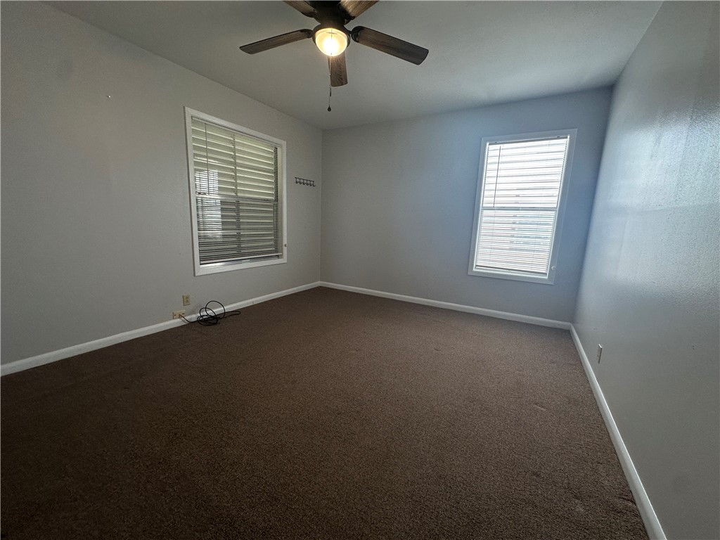 1133 Austin Street Portland, TX 78374 - Photo 18 of 32 an empty room with a window and a fan