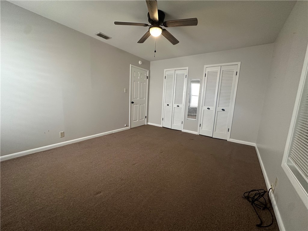 1133 Austin Street Portland, TX 78374 - Photo 20 of 32 an empty room with a ceiling fan and a window
