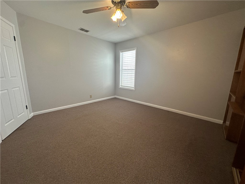 1133 Austin Street Portland, TX 78374 - Photo 26 of 32 an empty room with a chandelier fan and windows
