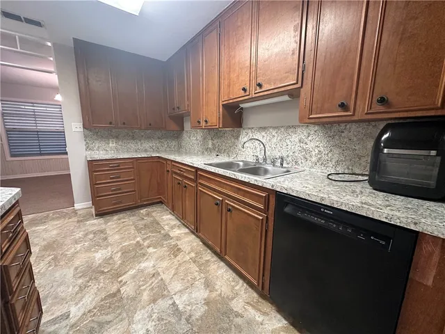 a kitchen with stainless steel appliances granite countertop a sink stove and cabinets