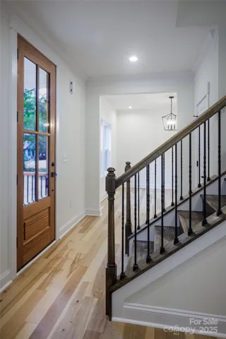 a view of a hallway with wooden floor and windows