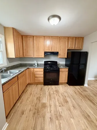 a large kitchen with granite countertop a stove top oven a sink dishwasher and a refrigerator