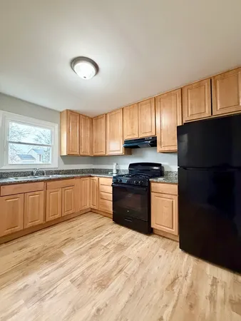 a kitchen with granite countertop a refrigerator stove top oven and sink