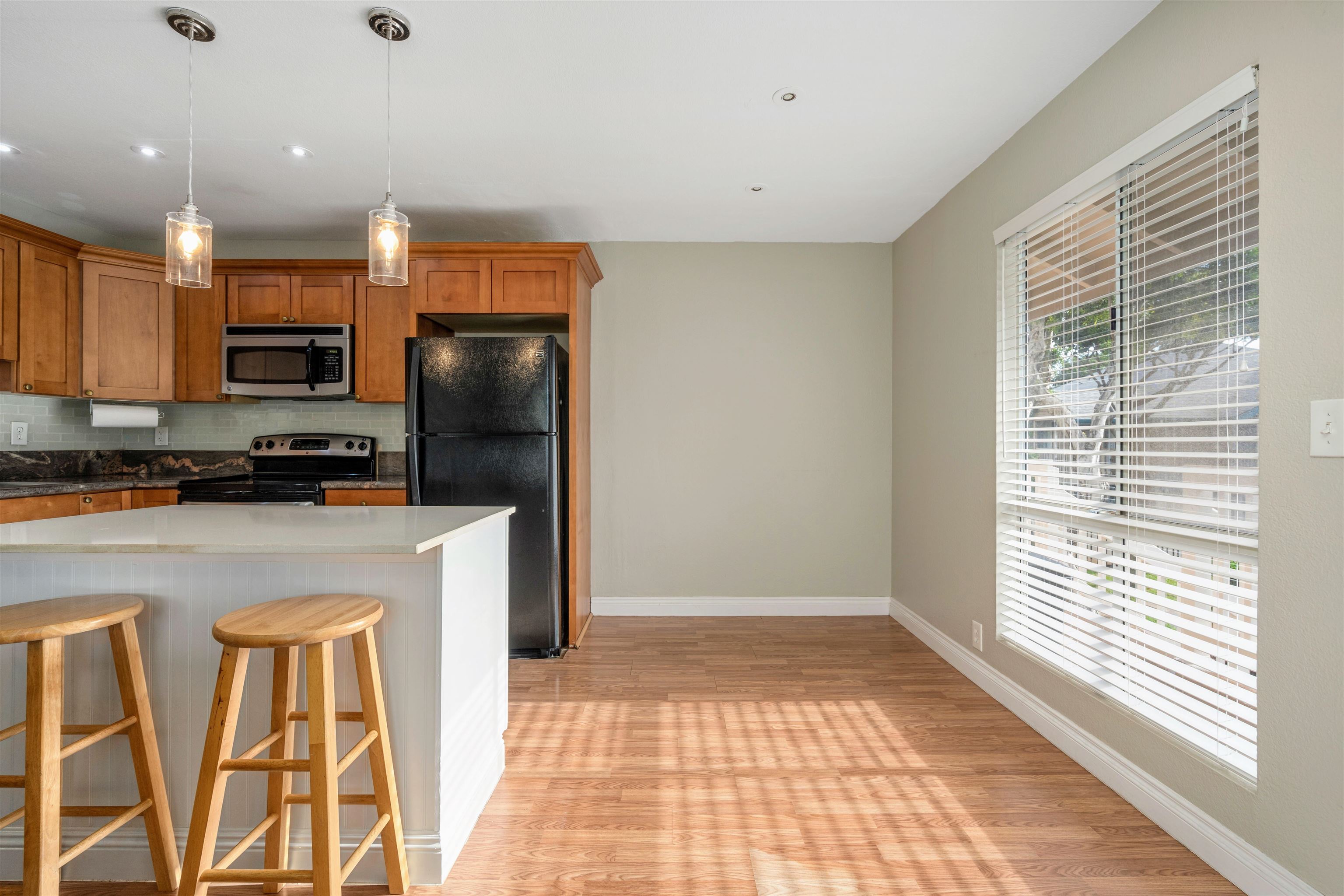 a kitchen with stainless steel appliances granite countertop a refrigerator a stove a sink and a window