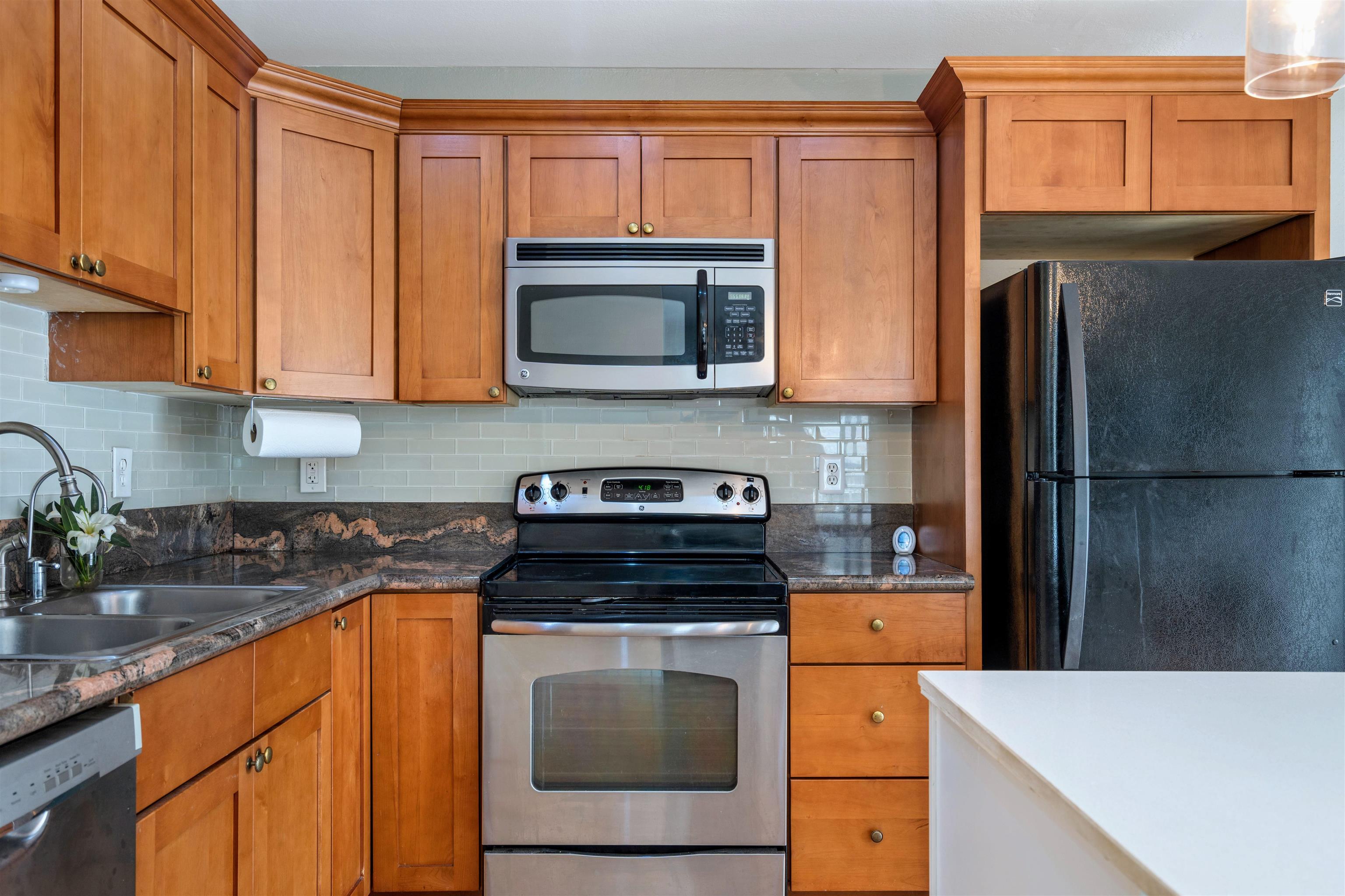 480 Kenolio Road, Unit 11206 Kihei, HI 96753 - Photo 4 of 31 a kitchen with stainless steel appliances granite countertop a refrigerator and a stove top oven