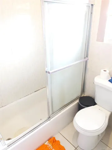 a white toilet sitting next to a bath tub