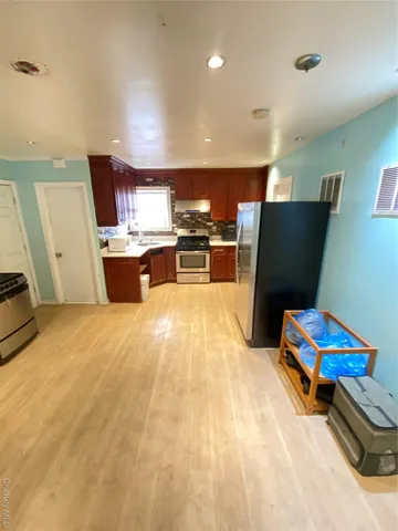 a kitchen with stainless steel appliances kitchen island granite countertop a sink dishwasher stove and refrigerator