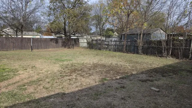 a backyard of a house with a trees and swing